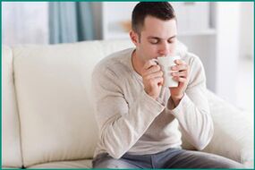 Un homme boit du thé à la menthe, voulant guérir la dysfonction érectile. 
